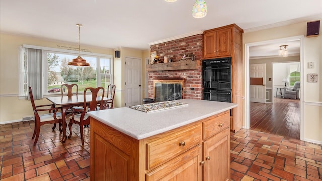 kitchen featuring dark wood-type flooring, black double oven, pendant lighting, a kitchen island, and ornamental molding