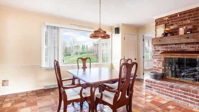 dining room with a fireplace and ornamental molding