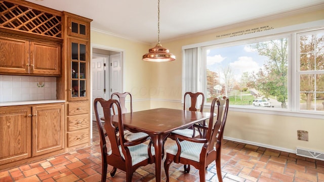 dining space with crown molding