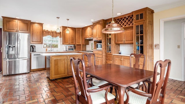 kitchen with tasteful backsplash, stainless steel appliances, a kitchen island, and hanging light fixtures