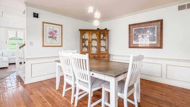 dining room featuring hardwood / wood-style floors and ornamental molding