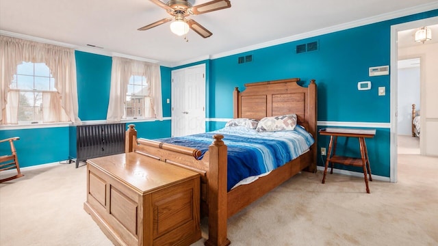 bedroom featuring ceiling fan, ornamental molding, light carpet, and a closet