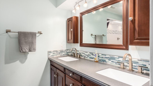 bathroom with vanity and tasteful backsplash