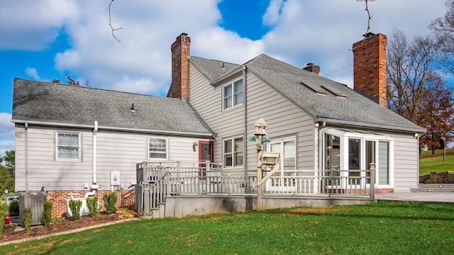 rear view of house with a lawn and cooling unit