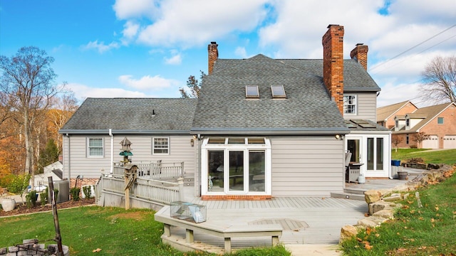 rear view of house with a lawn and a wooden deck