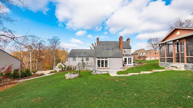 back of property with a yard, a patio, and a sunroom