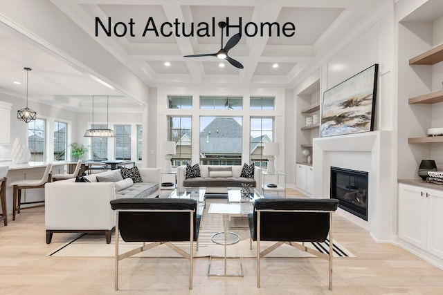 living room with coffered ceiling, built in shelves, ceiling fan, beamed ceiling, and light hardwood / wood-style floors