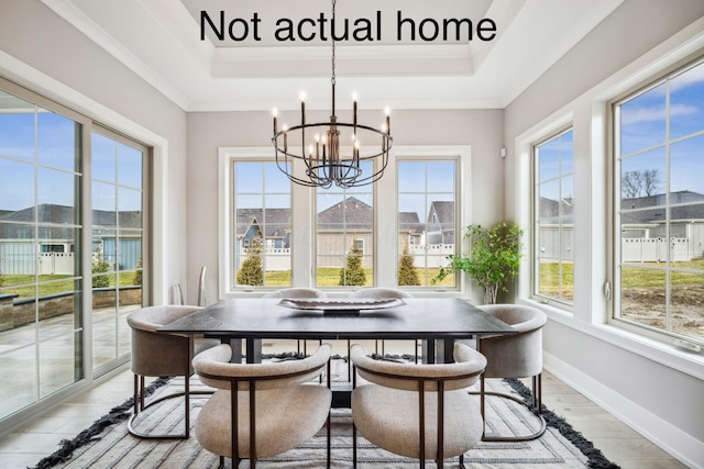 sunroom / solarium featuring a raised ceiling, a healthy amount of sunlight, and an inviting chandelier