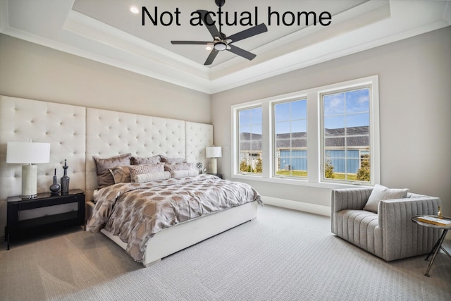 carpeted bedroom with ceiling fan, a raised ceiling, and ornamental molding