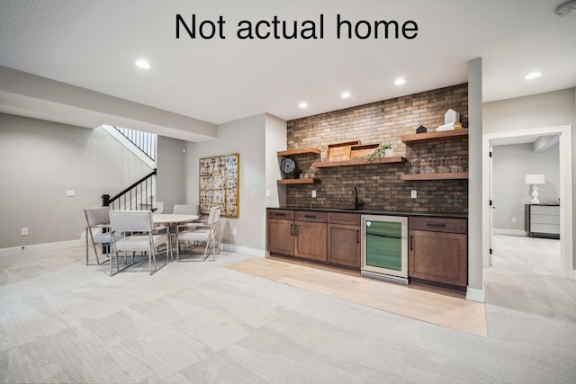 kitchen with light colored carpet, beverage cooler, and sink