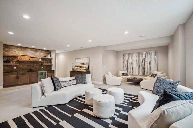 carpeted living room with indoor wet bar and brick wall