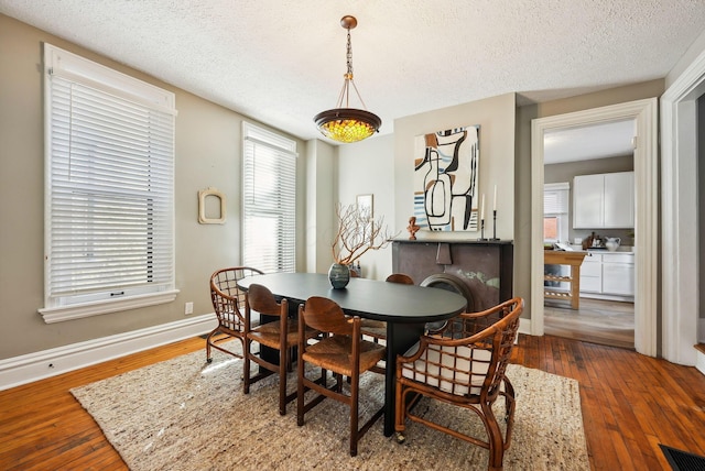 dining space featuring hardwood / wood-style floors and a textured ceiling