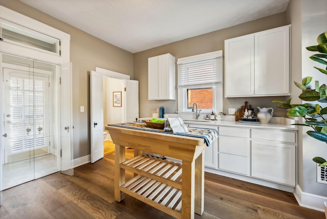 kitchen featuring dark hardwood / wood-style floors, plenty of natural light, white cabinetry, and sink