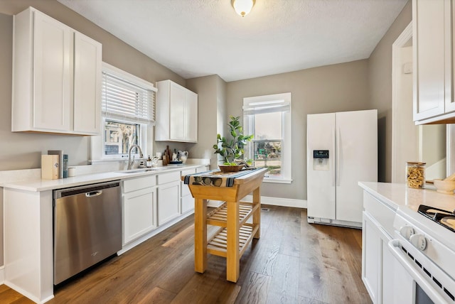 kitchen with white cabinets, white appliances, a wealth of natural light, and dark wood-type flooring