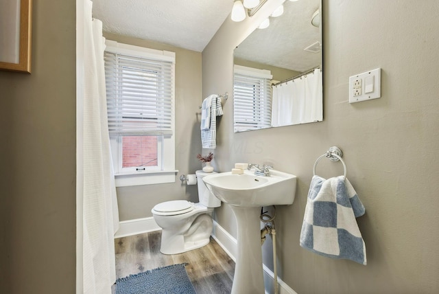 bathroom featuring hardwood / wood-style flooring, toilet, and a textured ceiling