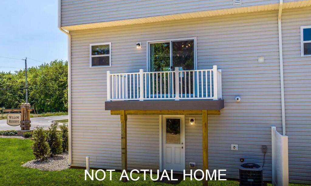 rear view of house featuring a balcony and central AC