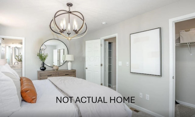 bedroom with carpet, ensuite bathroom, a spacious closet, a closet, and a chandelier