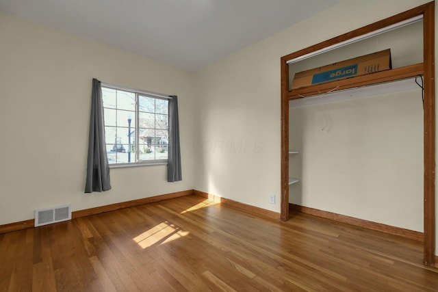 unfurnished bedroom featuring wood-type flooring and a closet