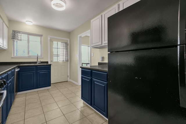 kitchen with blue cabinetry, white cabinetry, and appliances with stainless steel finishes