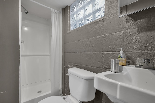 bathroom featuring a shower with curtain, toilet, and sink