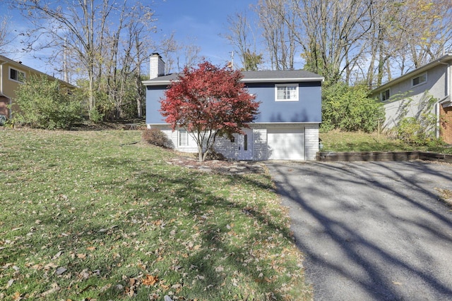 view of front of home with a garage and a front lawn