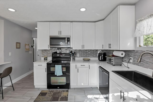 kitchen with decorative backsplash, white cabinetry, sink, and black appliances