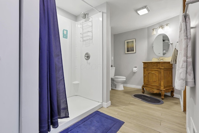 bathroom featuring toilet, vanity, wood-type flooring, and a shower with shower curtain