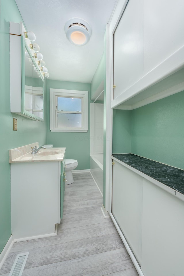 full bathroom featuring shower / bathing tub combination, wood-type flooring, vanity, and toilet