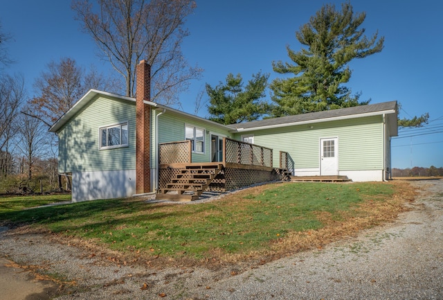 back of house featuring a wooden deck and a yard