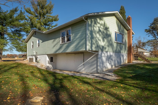 view of side of home with central air condition unit and a yard