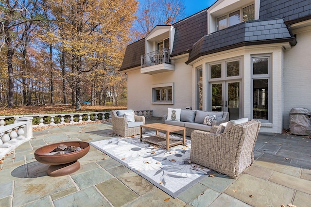 view of patio / terrace with a balcony, an outdoor hangout area, and french doors