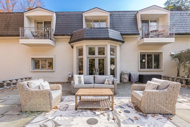 back of house featuring a patio area, a balcony, an outdoor hangout area, and french doors