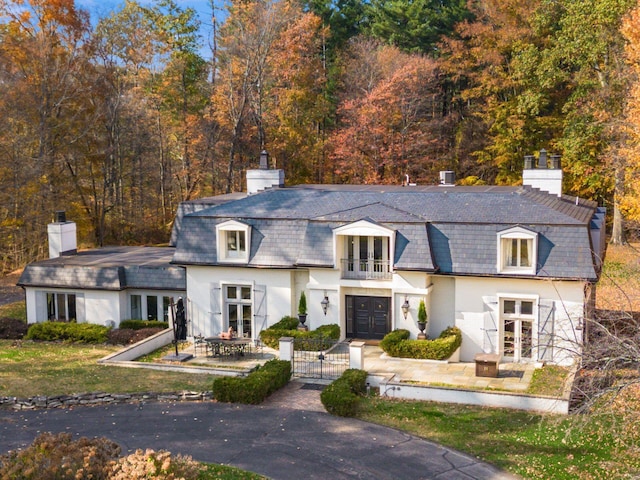 french country home featuring french doors and a balcony