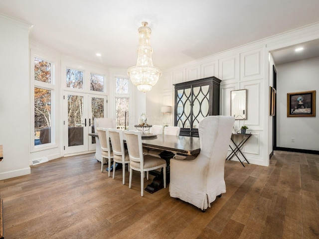 dining space featuring french doors, an inviting chandelier, dark wood-type flooring, and crown molding