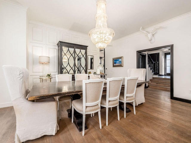 dining space featuring hardwood / wood-style flooring, plenty of natural light, ornamental molding, and a notable chandelier