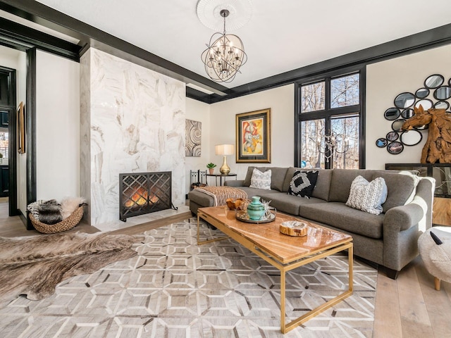 living room featuring hardwood / wood-style floors, a premium fireplace, and an inviting chandelier