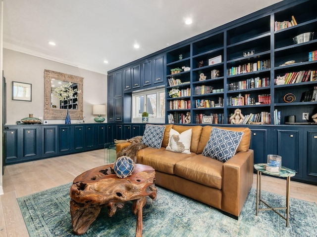 sitting room with crown molding and light wood-type flooring