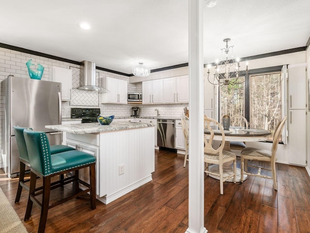 kitchen featuring white cabinetry, stainless steel appliances, wall chimney range hood, dark hardwood / wood-style flooring, and a kitchen island