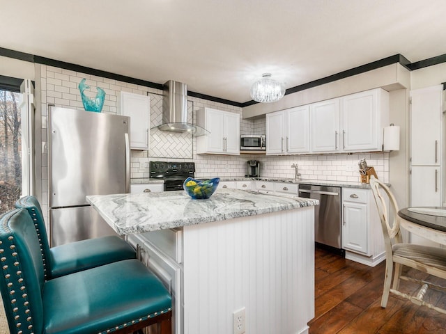 kitchen featuring appliances with stainless steel finishes, a center island, dark hardwood / wood-style floors, and wall chimney exhaust hood