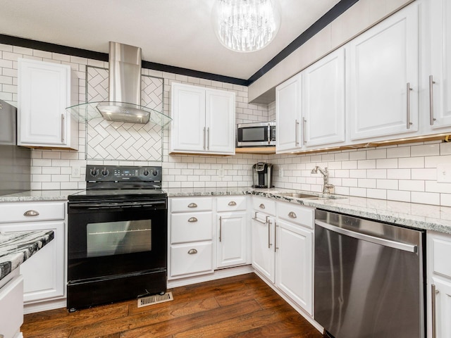 kitchen with white cabinetry, dark hardwood / wood-style floors, wall chimney range hood, and appliances with stainless steel finishes