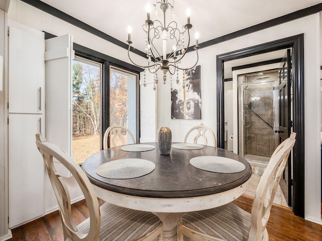 dining space featuring crown molding, dark hardwood / wood-style flooring, and a notable chandelier