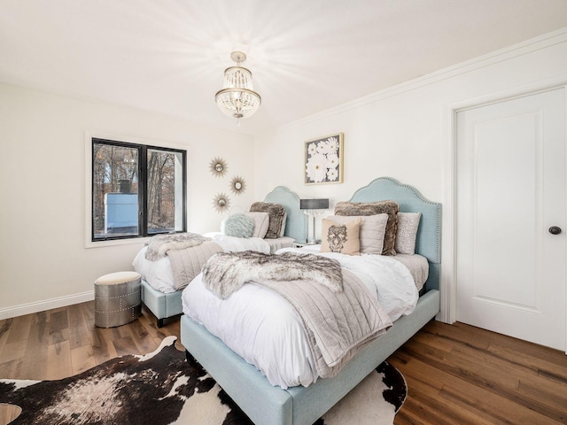 bedroom with a chandelier, crown molding, and dark wood-type flooring