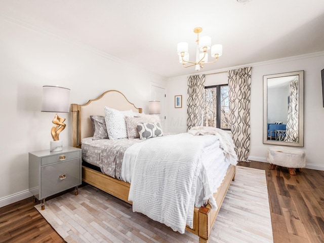 bedroom featuring ornamental molding, wood-type flooring, and an inviting chandelier