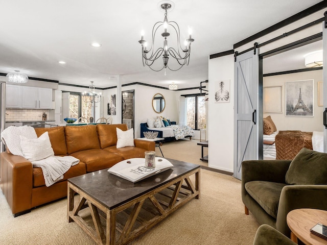 carpeted living room featuring a notable chandelier, a barn door, ornamental molding, and a wealth of natural light