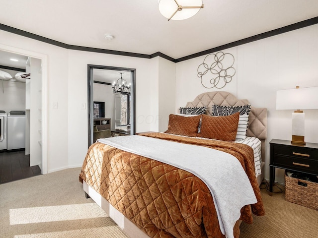 carpeted bedroom with a chandelier, washer and clothes dryer, and ornamental molding