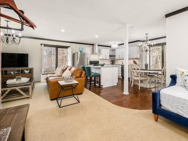 living room with crown molding, hardwood / wood-style floors, and a chandelier