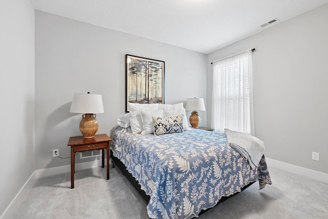 bedroom featuring carpet flooring and a textured ceiling