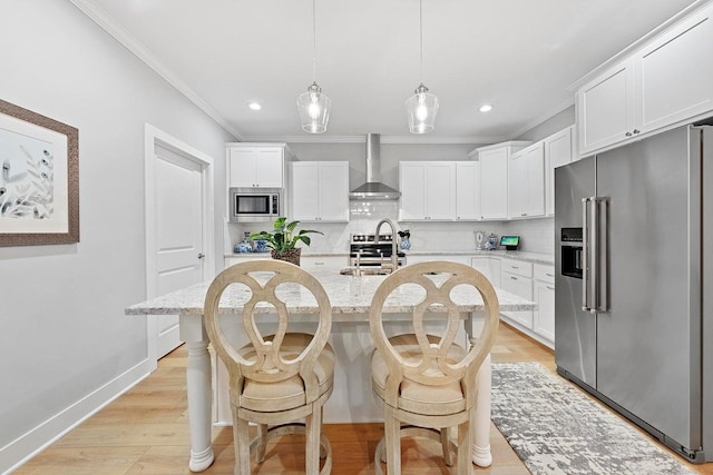 kitchen with backsplash, a kitchen island with sink, white cabinets, wall chimney exhaust hood, and stainless steel appliances