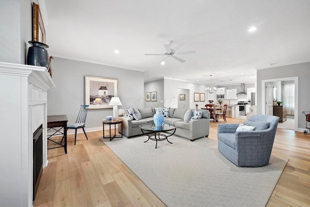 living room with crown molding, light hardwood / wood-style floors, and ceiling fan with notable chandelier