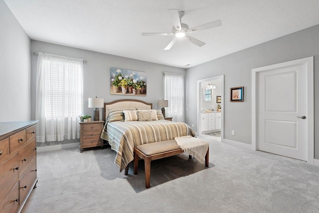 carpeted bedroom featuring a textured ceiling, ensuite bathroom, and ceiling fan